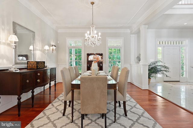 tiled dining room featuring plenty of natural light, crown molding, and an inviting chandelier