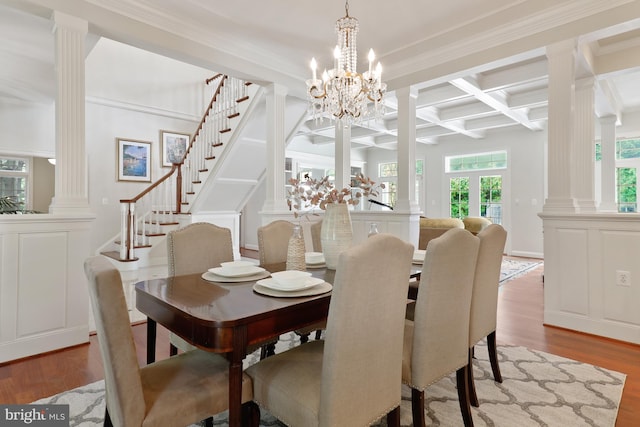 dining room featuring wood-type flooring, ornate columns, coffered ceiling, and beamed ceiling