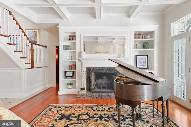 misc room featuring wood-type flooring, a premium fireplace, and coffered ceiling