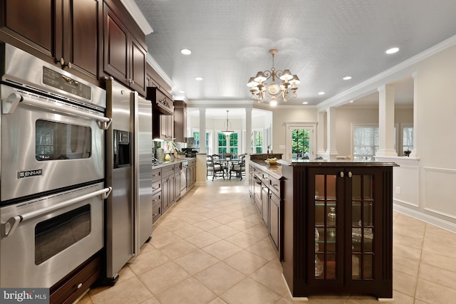 kitchen with a center island, decorative light fixtures, stainless steel appliances, ornamental molding, and an inviting chandelier