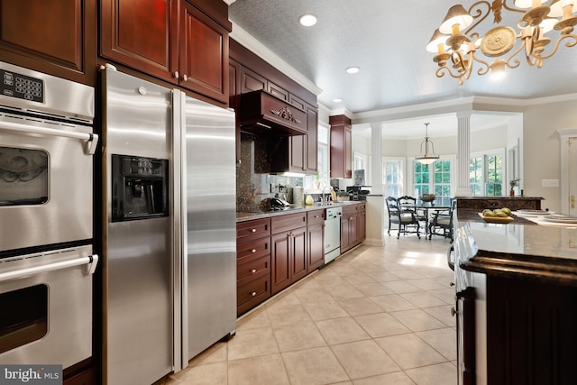 kitchen featuring decorative light fixtures, light stone countertops, ornamental molding, an inviting chandelier, and stainless steel appliances