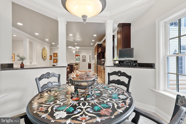 dining space with ornate columns, a notable chandelier, and ornamental molding