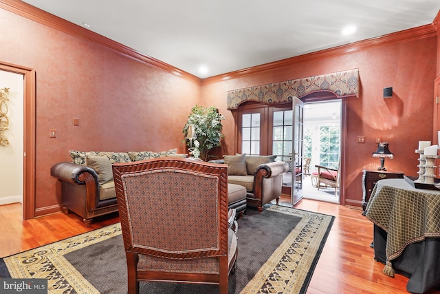 living room with french doors, ornamental molding, and light hardwood / wood-style floors