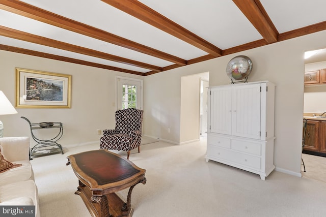 sitting room featuring beam ceiling and light carpet