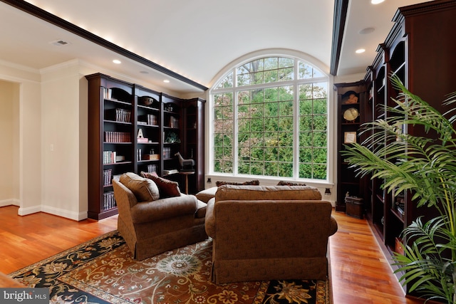 living room with hardwood / wood-style floors and crown molding