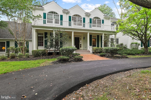 view of front facade with a balcony and covered porch