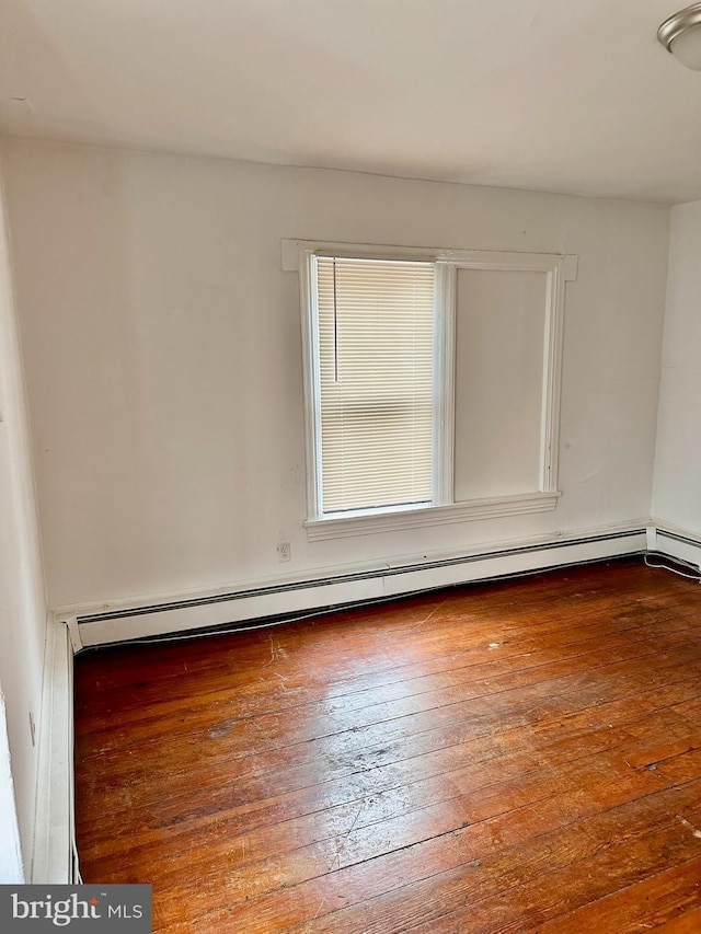 spare room with a baseboard radiator and hardwood / wood-style floors