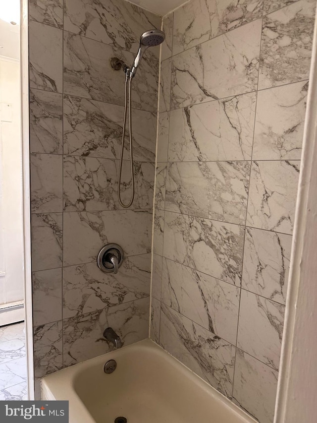 bathroom featuring tiled shower / bath and baseboard heating