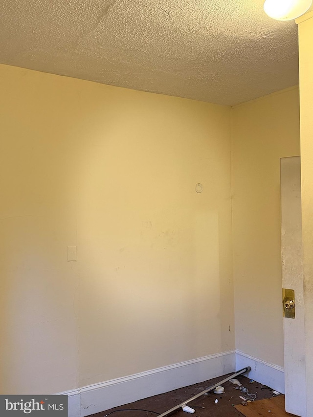 unfurnished room featuring a textured ceiling