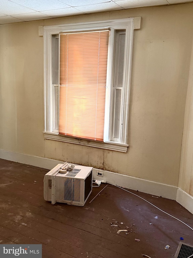 unfurnished room featuring an AC wall unit and dark hardwood / wood-style floors