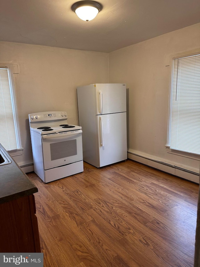 kitchen with a baseboard radiator, plenty of natural light, hardwood / wood-style floors, and white appliances