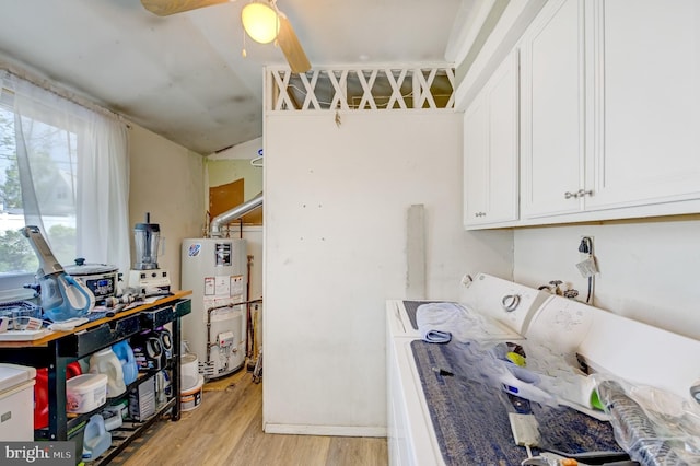 laundry room with ceiling fan, light hardwood / wood-style floors, washing machine and clothes dryer, gas water heater, and cabinets