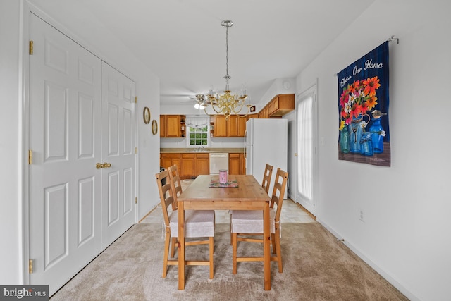 dining space featuring light colored carpet, sink, and an inviting chandelier