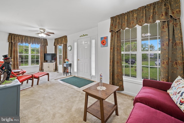 living room featuring a healthy amount of sunlight, ceiling fan, and carpet