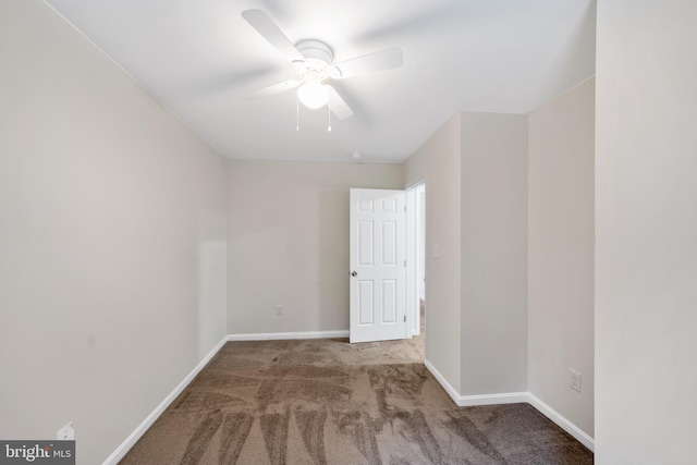 carpeted spare room featuring ceiling fan