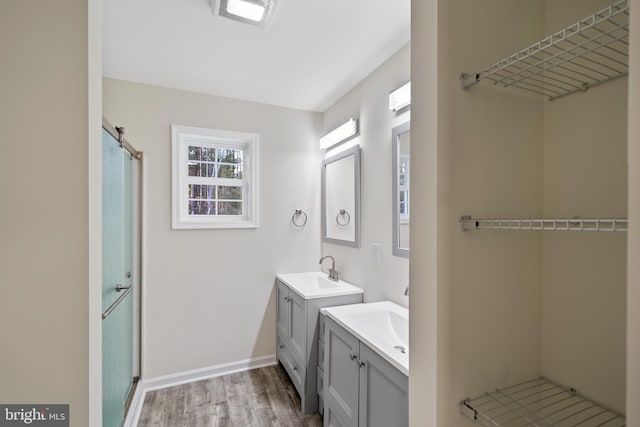 bathroom featuring hardwood / wood-style flooring, vanity, and a shower with door