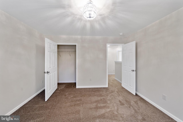 unfurnished bedroom featuring a closet, a chandelier, and carpet flooring