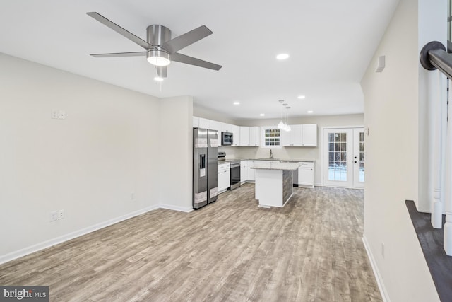 kitchen featuring a kitchen island, pendant lighting, white cabinetry, light hardwood / wood-style floors, and stainless steel appliances