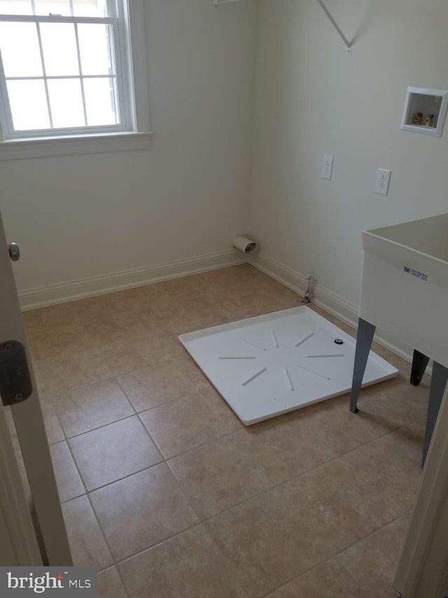 washroom with light tile patterned flooring and hookup for a washing machine