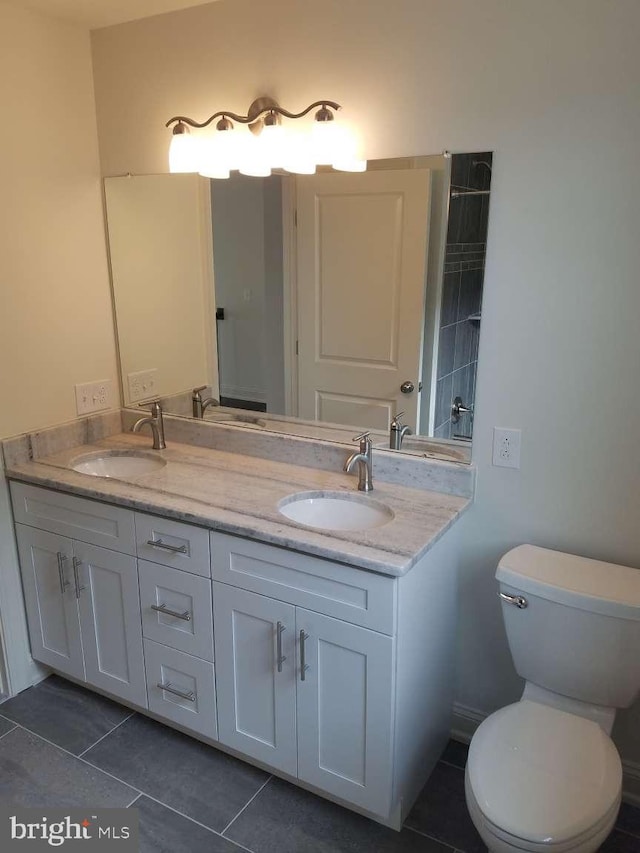 bathroom featuring toilet, vanity, and tile patterned floors