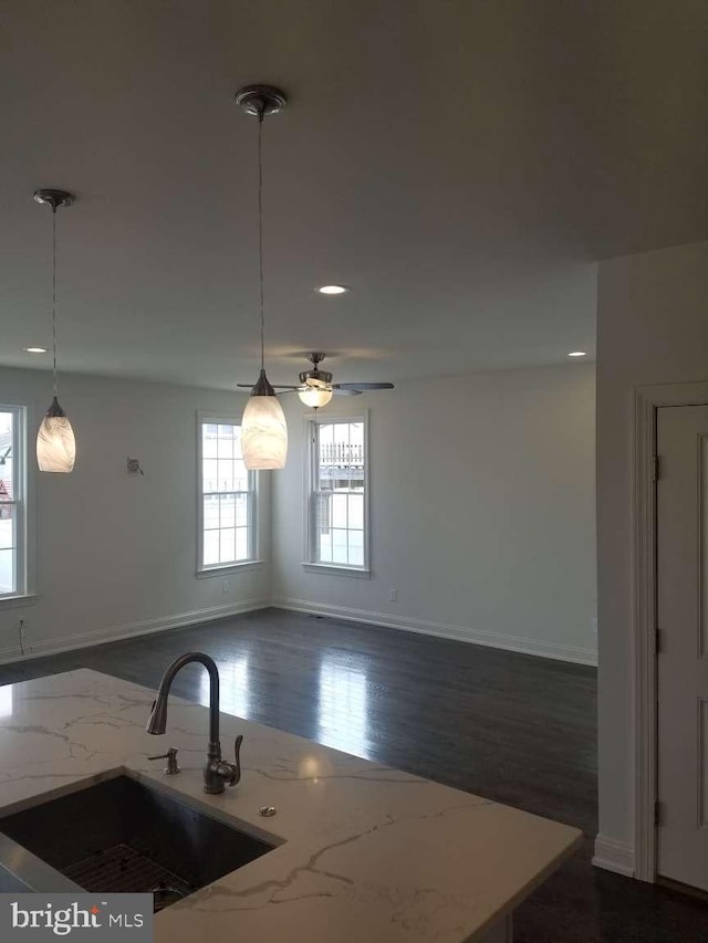 kitchen featuring decorative light fixtures, sink, ceiling fan, and dark wood-type flooring