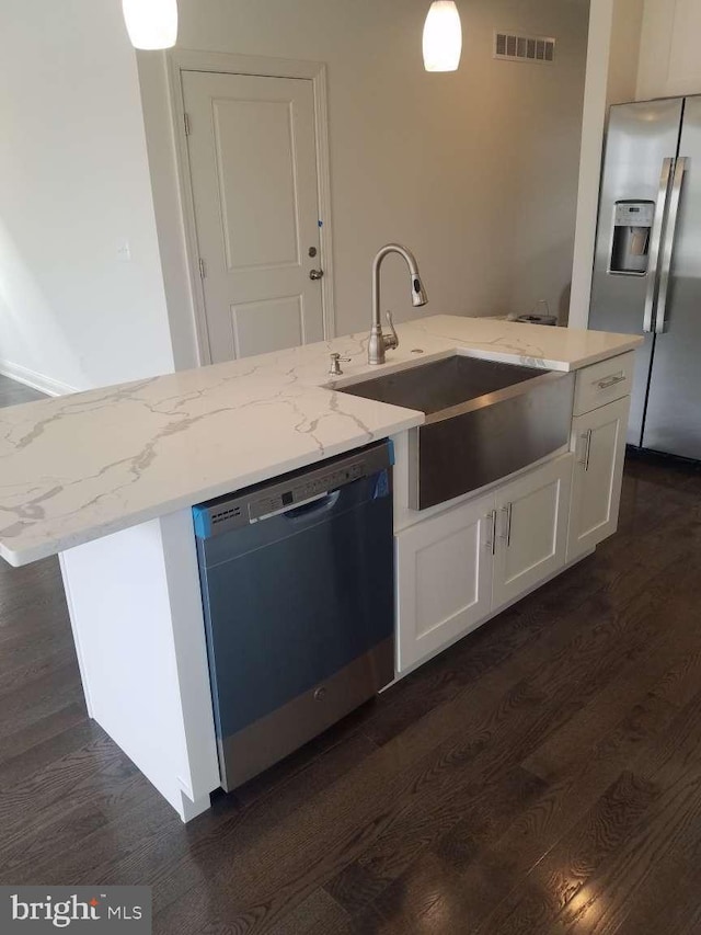 kitchen with dishwashing machine, white cabinets, sink, stainless steel fridge with ice dispenser, and a center island with sink