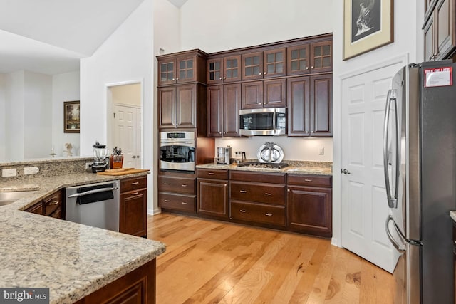 kitchen featuring dark brown cabinets, stainless steel appliances, and light hardwood / wood-style floors