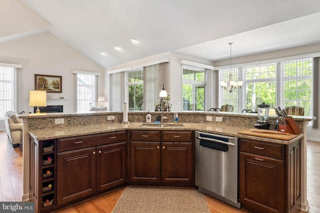 kitchen featuring lofted ceiling, stainless steel dishwasher, sink, and a wealth of natural light