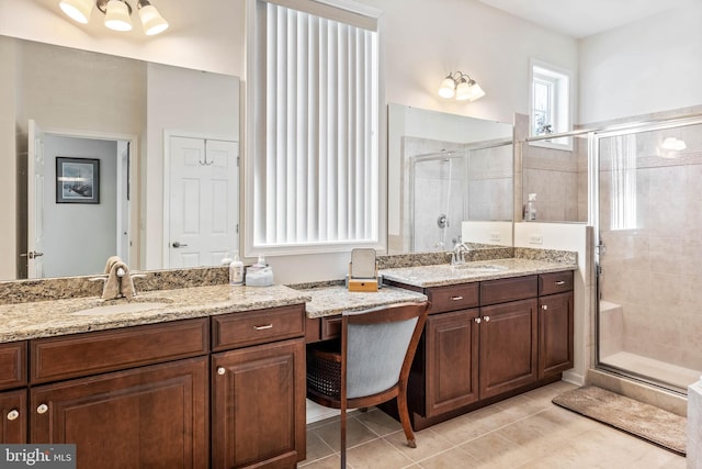 bathroom with a shower with door, vanity, and tile patterned flooring