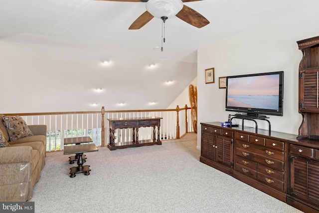 living room featuring ceiling fan, vaulted ceiling, and light colored carpet