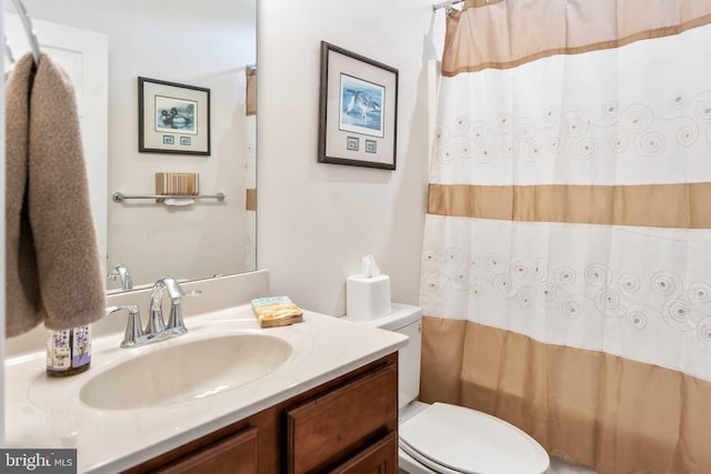 bathroom featuring vanity, curtained shower, and toilet