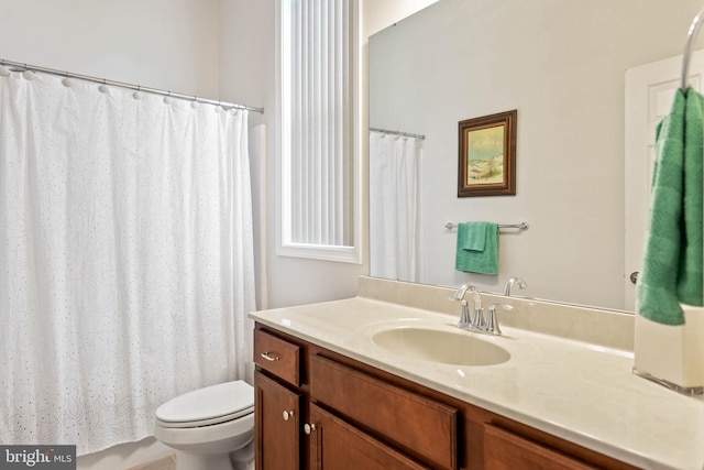 bathroom featuring toilet, vanity, and a shower with shower curtain