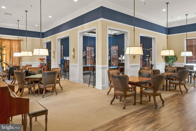 dining space with ornamental molding and wood-type flooring