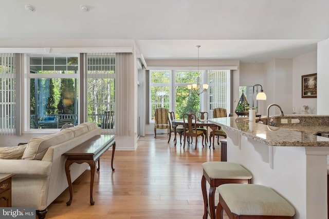 living room with light hardwood / wood-style flooring and a notable chandelier