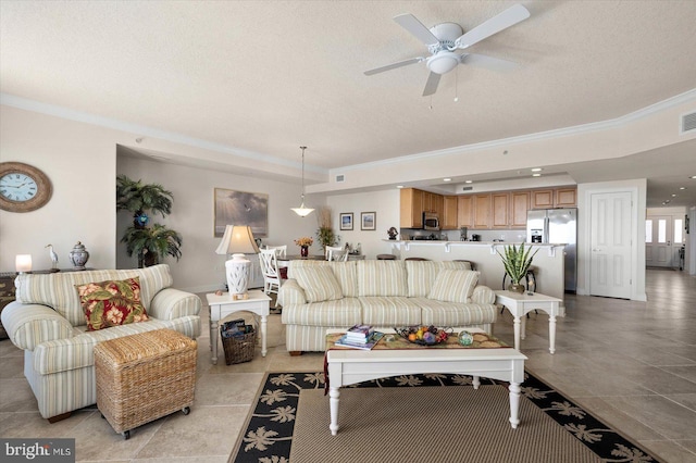 tiled living room featuring crown molding, ceiling fan, and a textured ceiling