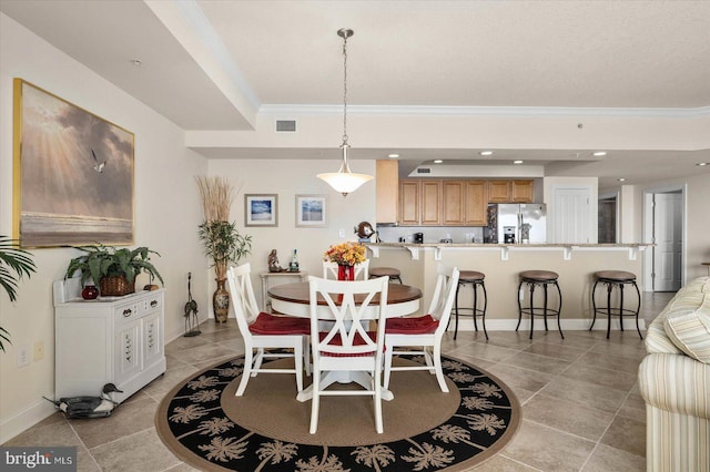 dining area with crown molding and light tile floors