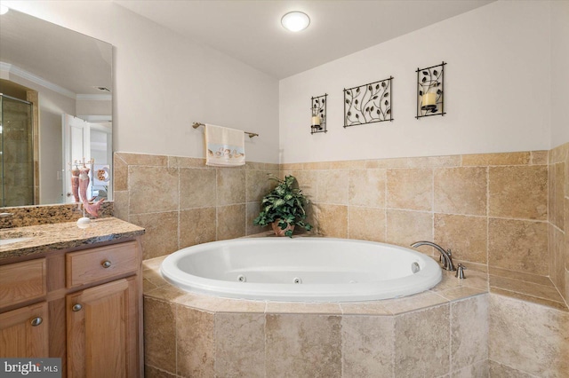 bathroom with vanity and a relaxing tiled bath