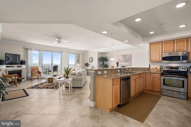 kitchen with light stone countertops, kitchen peninsula, appliances with stainless steel finishes, ceiling fan, and light tile floors