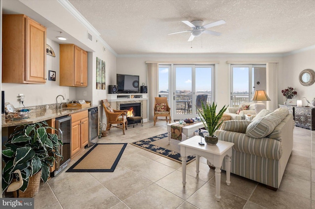 living room with a fireplace, a wealth of natural light, light tile floors, and ornamental molding