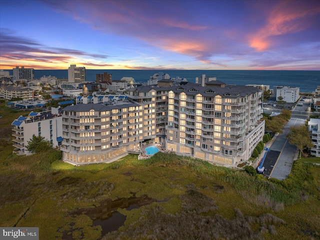 aerial view at dusk featuring a water view