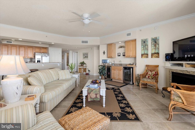 living room with wine cooler, ceiling fan, crown molding, and light tile floors