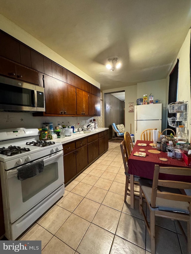 kitchen with white appliances and light tile floors