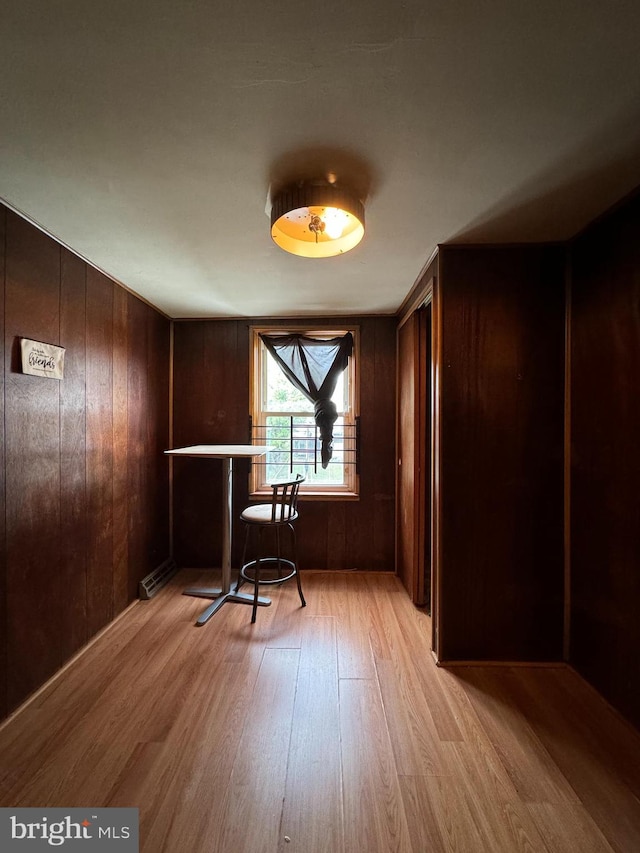 interior space with light hardwood / wood-style flooring and wooden walls