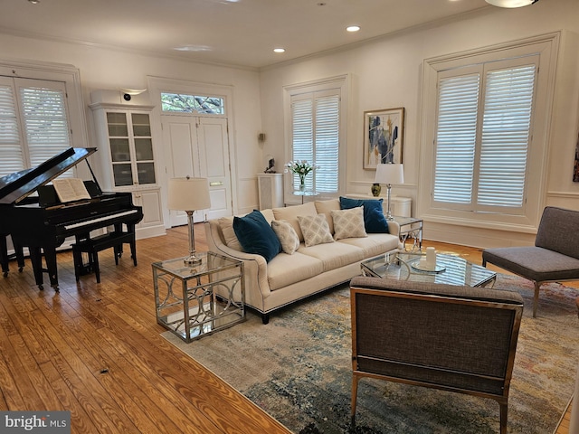 living room with plenty of natural light, hardwood / wood-style floors, and crown molding