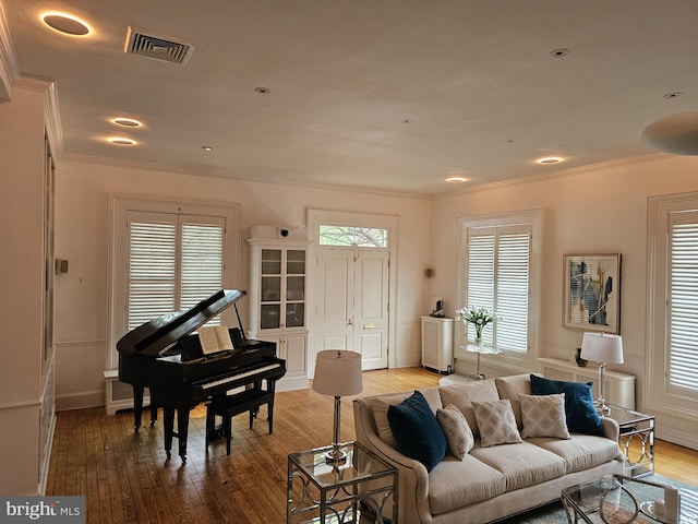 living room featuring crown molding and light hardwood / wood-style floors