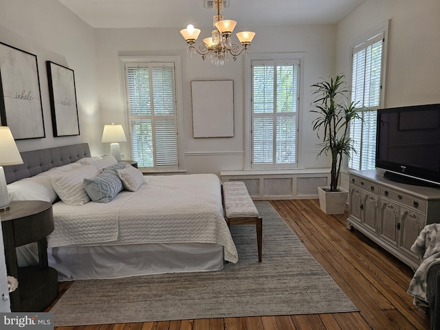 bedroom with dark hardwood / wood-style flooring and a notable chandelier