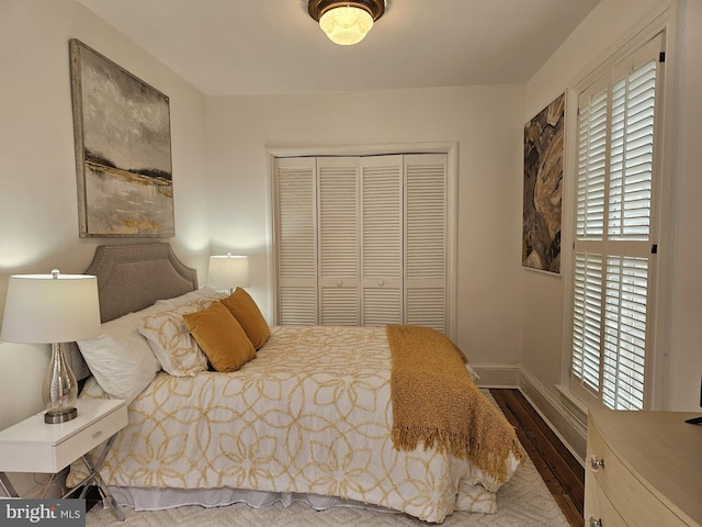 bedroom featuring dark hardwood / wood-style flooring, a closet, and multiple windows