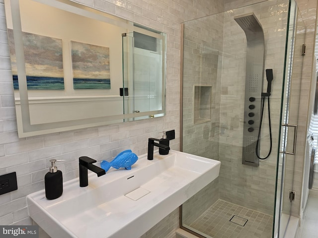 bathroom with tile walls, sink, tasteful backsplash, and walk in shower