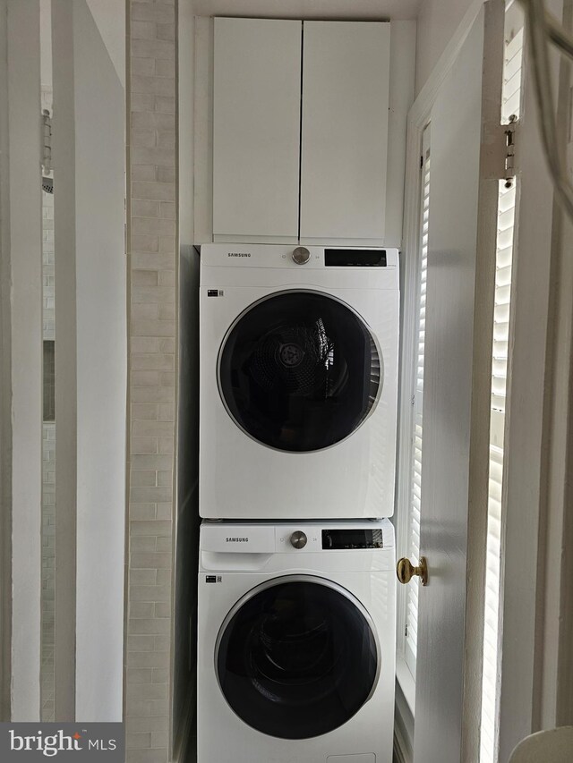 laundry area featuring stacked washer / drying machine