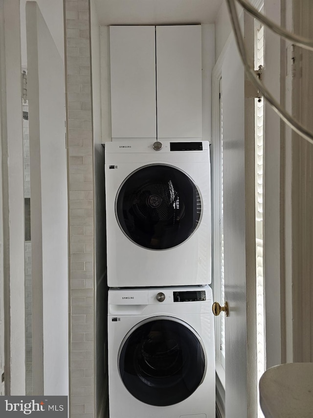 laundry area with stacked washing maching and dryer